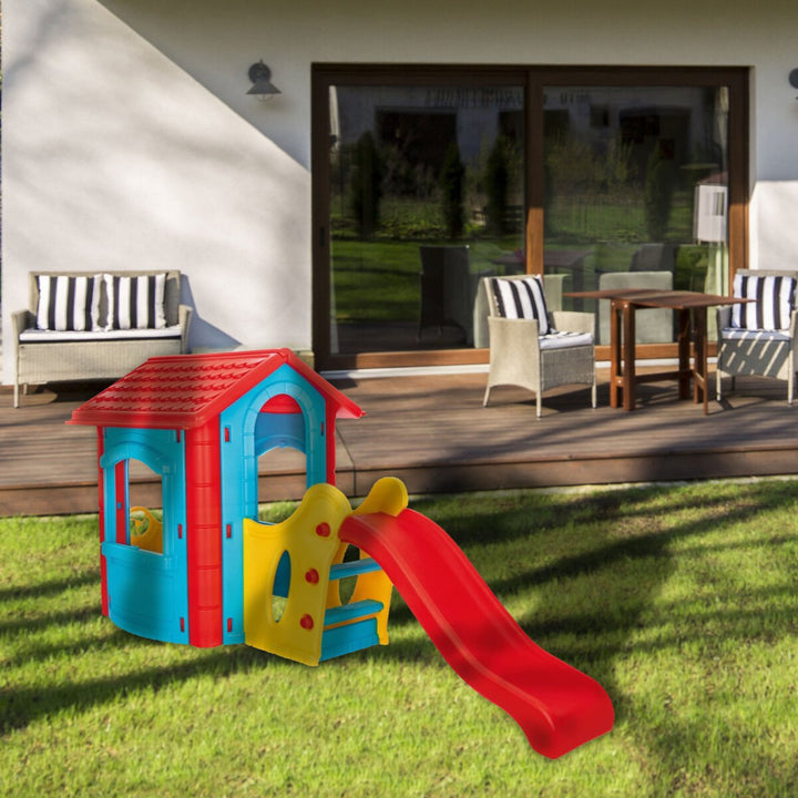Colorful playground slide and playhouse on grass with a house in the background