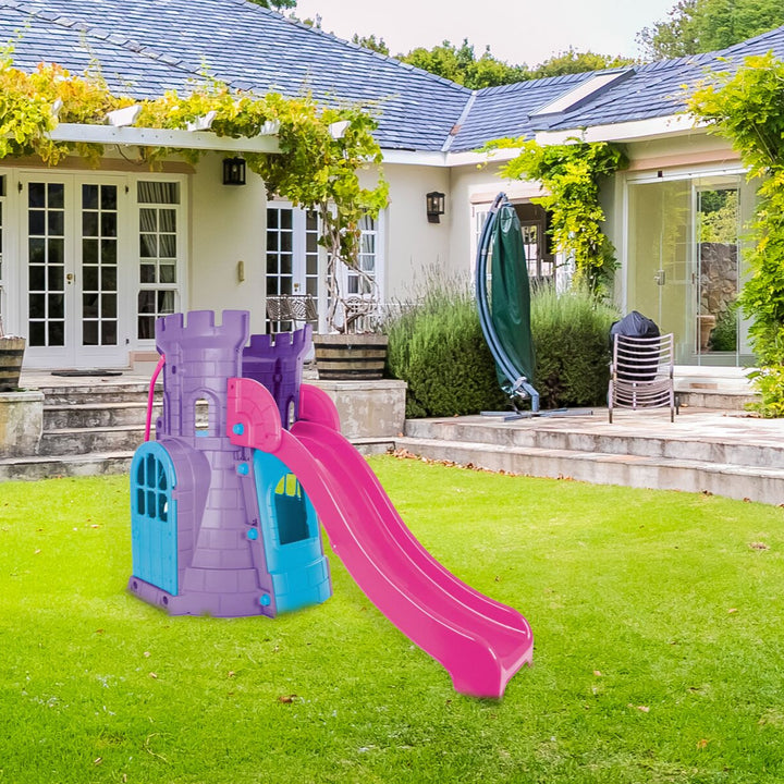 Colorful playground slide and castle in a garden with a house in the background